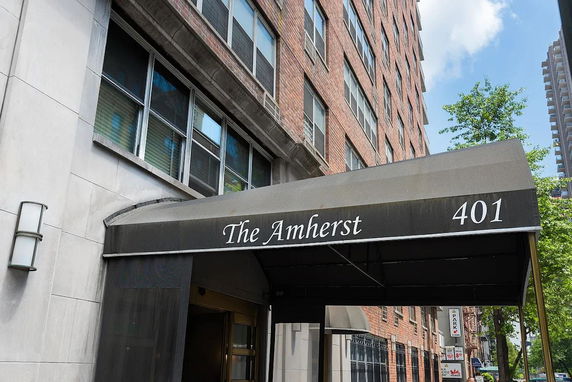 Front view of a brick apartment building with an entrance canopy labeled 'The Amherst 401.'