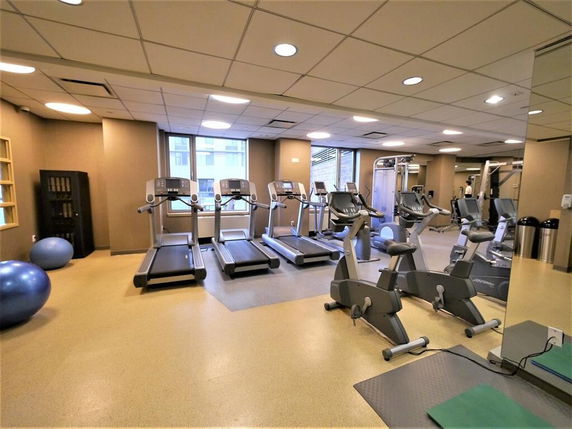 Gym area with treadmills, stationary bikes, and exercise equipment.