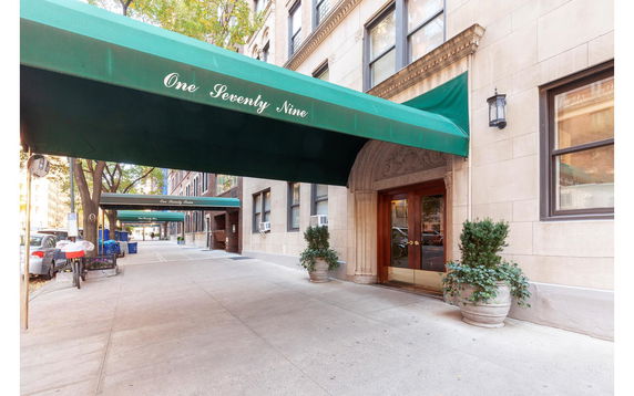 Front view of a building entrance with green awnings.