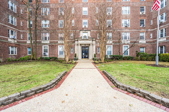 Front view of a multi-story brick building with decorative entrance.