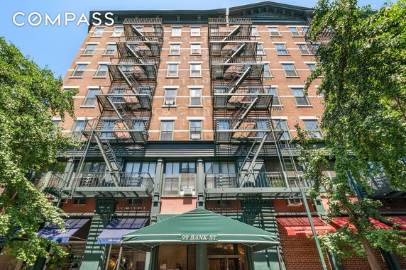 Front view of a multi-story brick building with fire escapes.