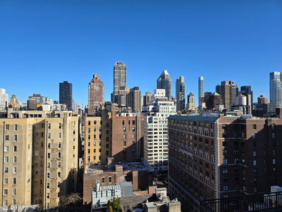 Wide view of city buildings under a clear blue sky