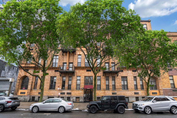 Front view of a multi-story brick building with balconies.