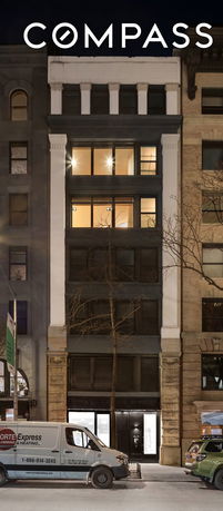 Front view of a multi-story building with large windows and a classic facade.