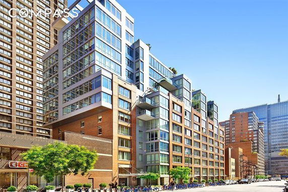 Front view of a modern multi-story building with large windows and balconies.
