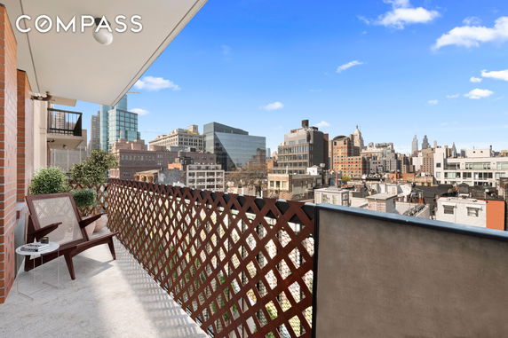 Balcony with cityscape view including various buildings and structures.