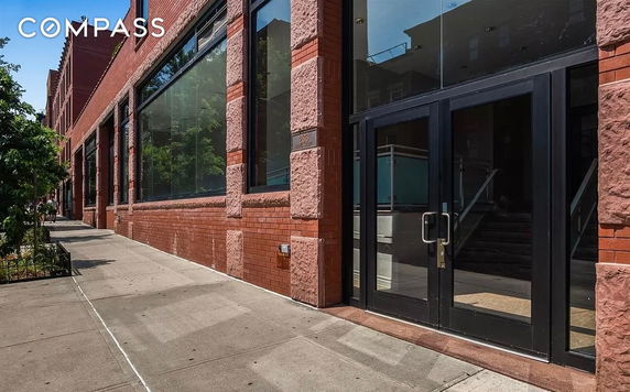 Front view of a brick building with large windows and glass doors.