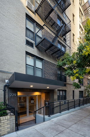 Front view of a multi-story building with fire escape stairs.