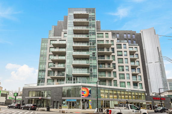 Front view of a modern multi-story apartment building with balconies.