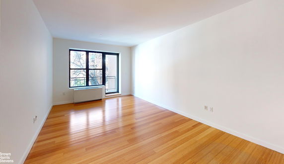 Elevated view of a single-story house with a large front window and a small garden area.