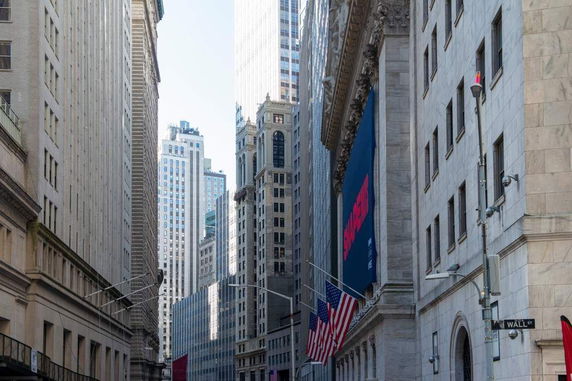 Street view of tall buildings with large banners and flags.