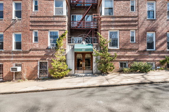 Front view of a brick apartment building with an entrance canopy.