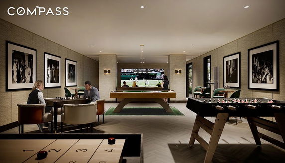 Interior view of a recreational room with various game tables and a large screen.