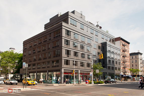 Front view of a modern multi-story building on a city corner.