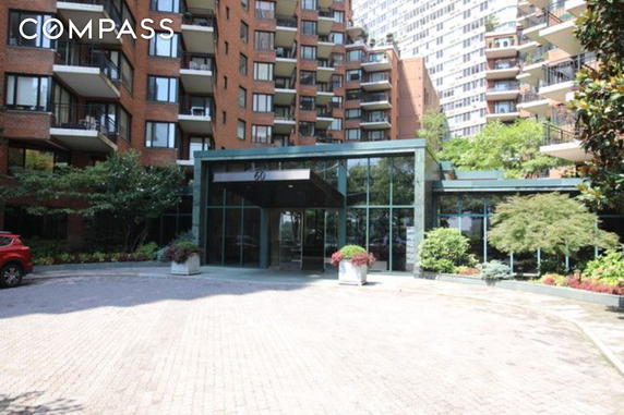 Front view of a multi-story building with balconies and a glass entrance.