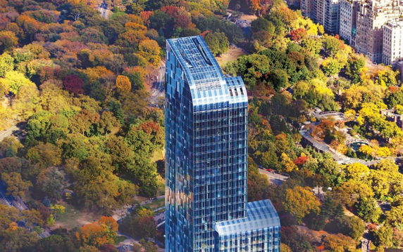 Panoramic view of a tall glass skyscraper surrounded by colorful autumn trees.