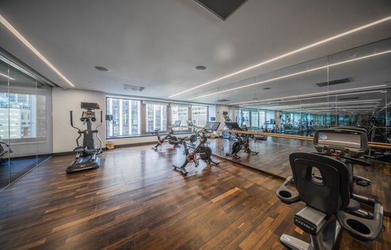 Interior view of a gym area with exercise bikes and mirrored walls.