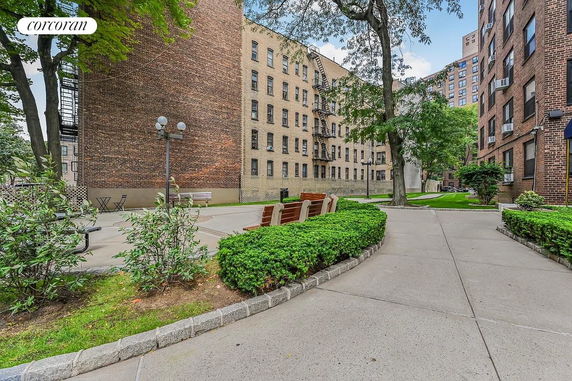 View of the exterior of apartment buildings with brick facade and outdoor seating area.
