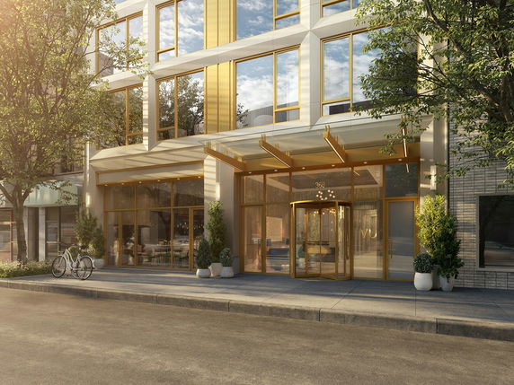 Front view of a modern multi-story building with large glass entrance and revolving door.