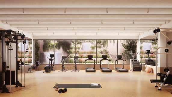 Interior view of a gym with exercise equipment and large windows.