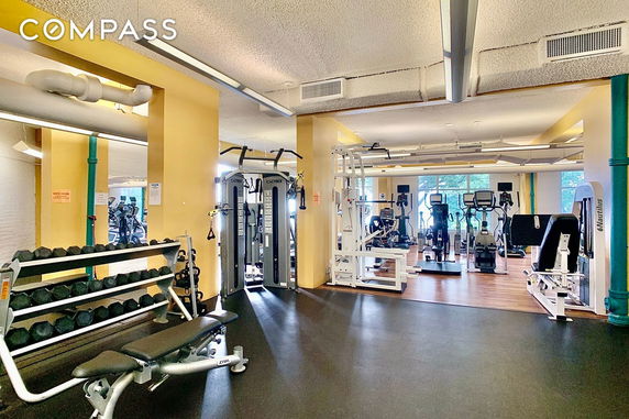 Interior view of a gym with exercise equipment and weights.