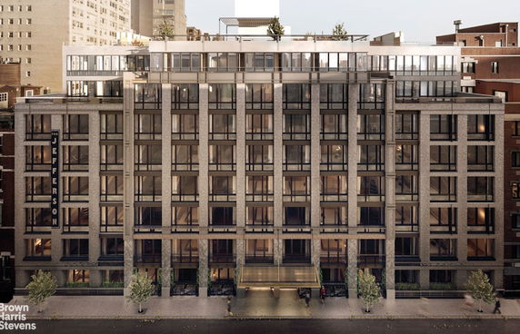 Front view of a multi-story apartment building with large windows and a modern façade.
