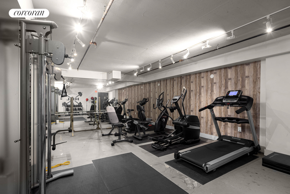Indoor gym area with various exercise equipment and machines.