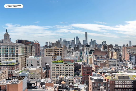 Panoramic view of a cityscape with numerous buildings under a blue sky.