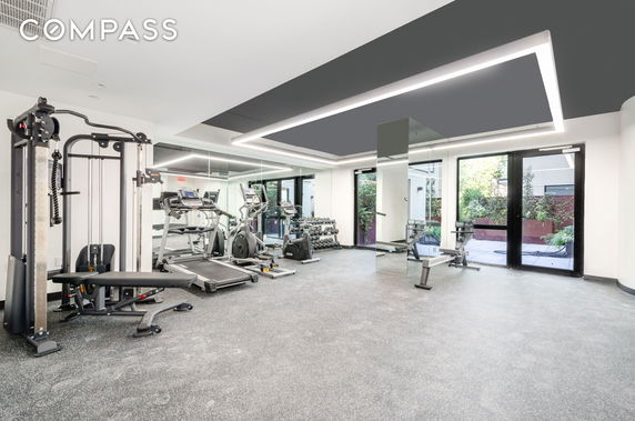 Indoor gym area with exercise equipment and mirrors.