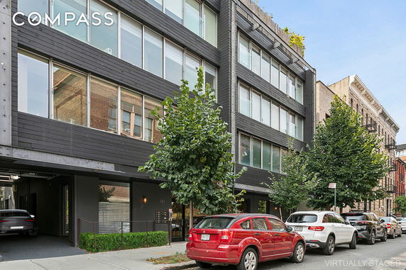 Front view of a multi-story modern building with large windows.