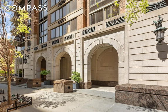 Front view of a multi-story building with arched entrances and large windows.