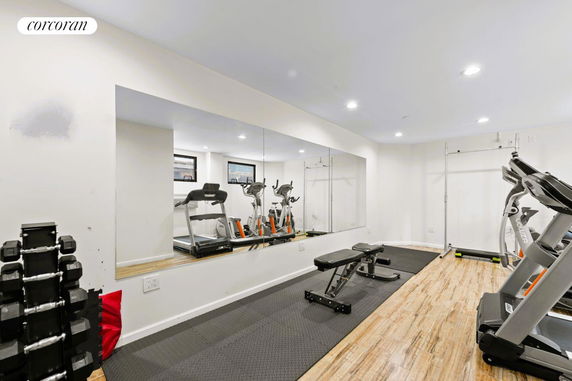 Indoor gym area with exercise equipment and mirrored wall.