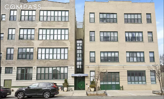 Front view of a multi-story building with large windows and a central entrance.