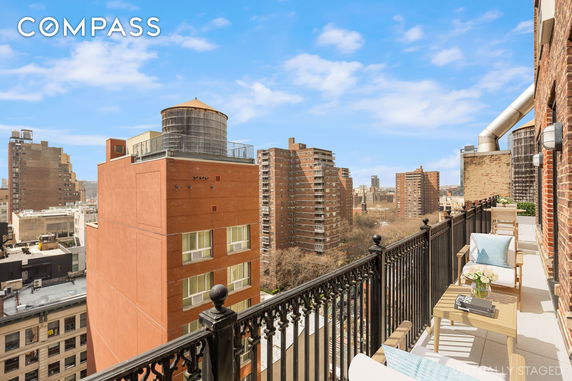Panoramic view from a balcony overlooking city buildings.