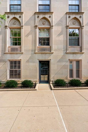 Front view of a multi-story building with decorative windows and a central entrance.
