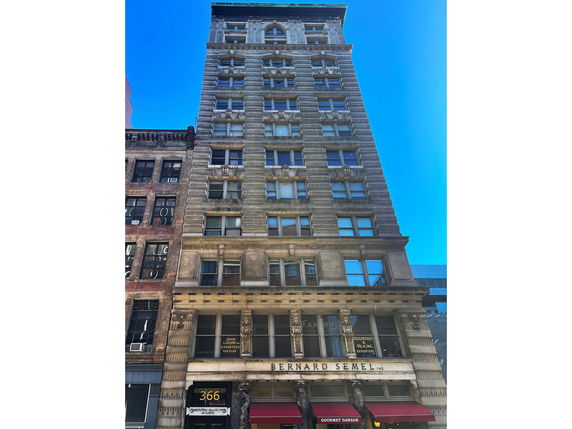 Front view of a tall, multi-story building with ornate architectural details.
