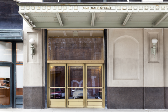 Front view of a building entrance with a large glass door and canopy.