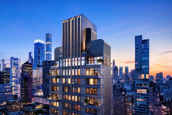 View of a modern high-rise building in a cityscape at dusk with skyscrapers in the background.