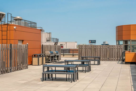 Rooftop area with outdoor seating and barbecue grills.