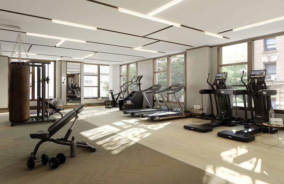 Interior view of a gym with exercise equipment like treadmills and weights.