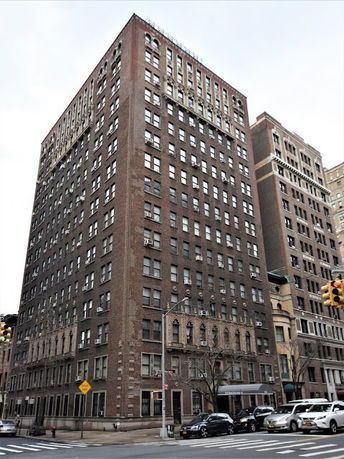 Front view of a tall brick apartment building.