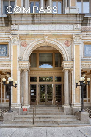 Front view of a grand building with ornate architectural details and a prominent arched entrance.