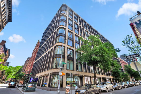 Front view of a multi-story building on a city street corner.