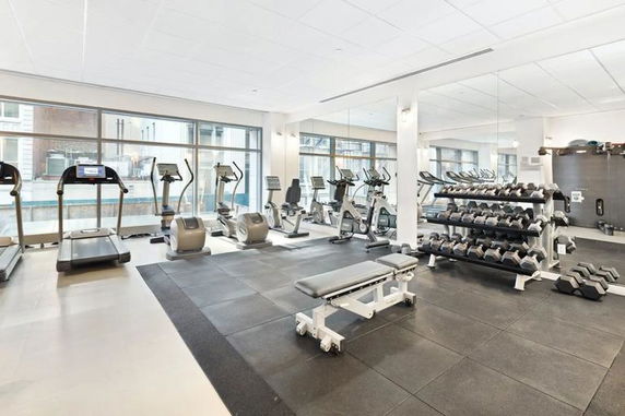 Interior view of a gym with exercise equipment and weights.