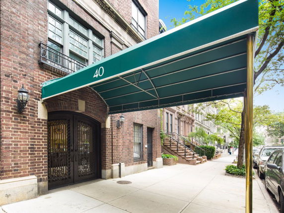 Front view of a brick building with a green canopy over the entrance.
