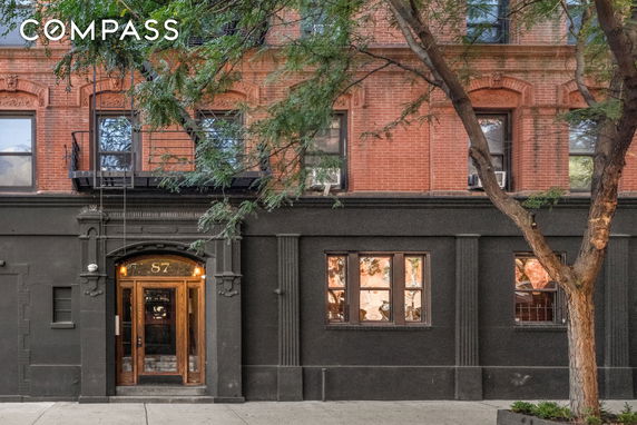 Front view of a multi-story brick building with decorative elements and a main entrance.