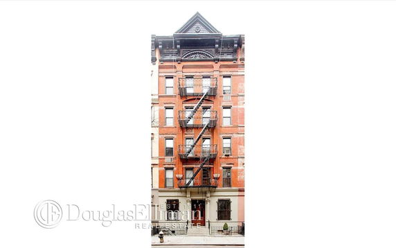 Front view of a multi-story brick building with fire escapes.
