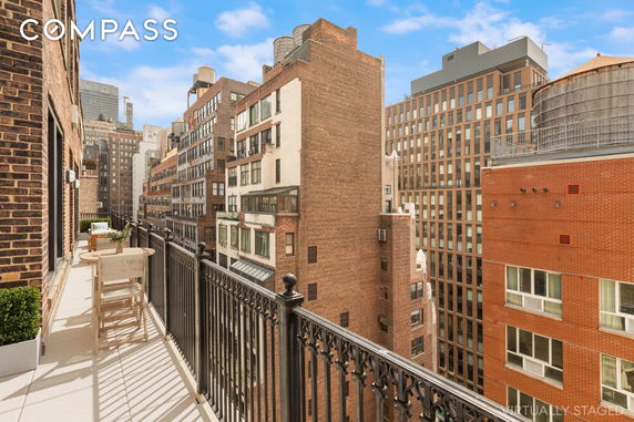View of surrounding buildings from a balcony, with adjacent brick structures in a city setting.