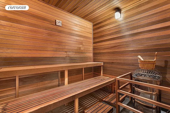 Interior view of a wooden sauna with benches and a heater.