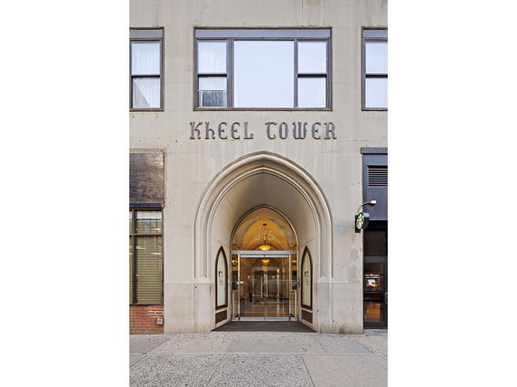 Front view of a building entrance with an arched doorway and glass doors.
